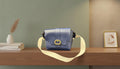 Blue Leather Crossbody Bag with a Gold Buckle and Cream Strap